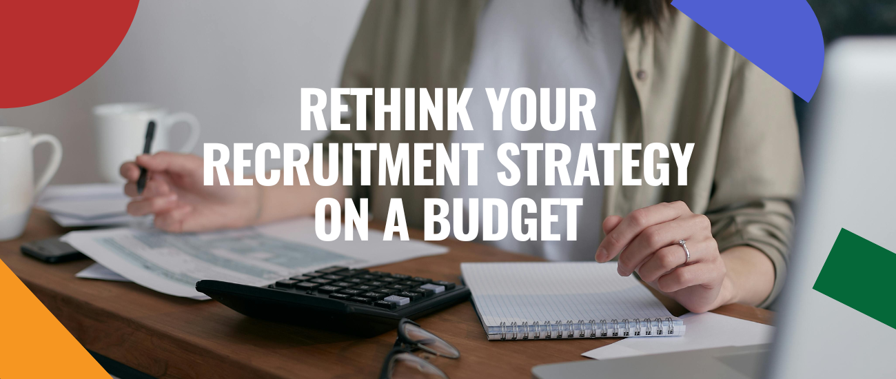 Business woman using a calculator and reviewing recruitment documents at a desk, illustrating budget-conscious hiring decisions.